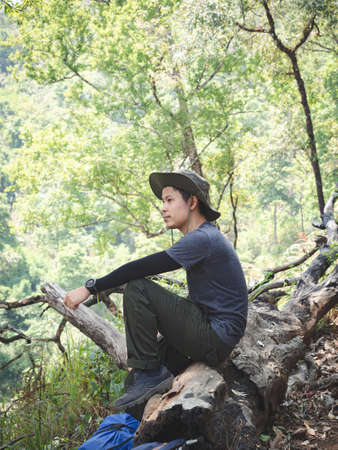 Portrait of Asian traveler man with backpack on a hiking trip in forest.の写真素材