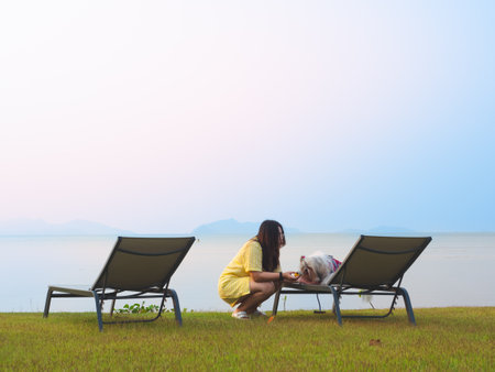 Asian woman and her cute dog enjoy summer day on the beach with relaxing lifestyleの写真素材