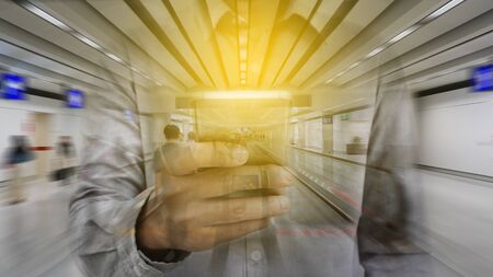 Double exposure of hand hold and touch screen smart phone with airport blurry background.の写真素材