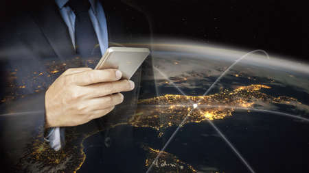 Double exposure of hand hold  smart phone with world background