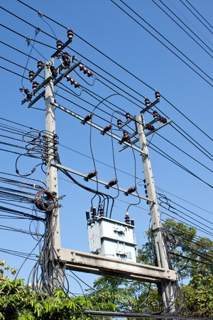 electrical post by the road with power line cables, transformers and phone linesの写真素材