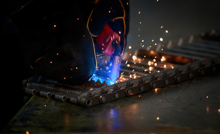 Industrial Worker at the factory welding steelの写真素材