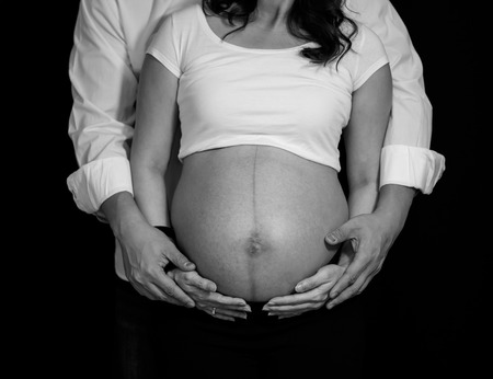 Close up of pregnant holds hands on belly.の写真素材