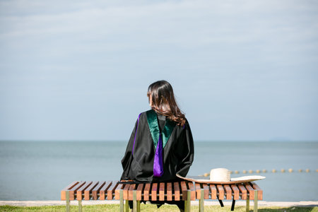 Women  a graduation  clothing sit  at the beach, Relaxing  summer holiday and travelの写真素材