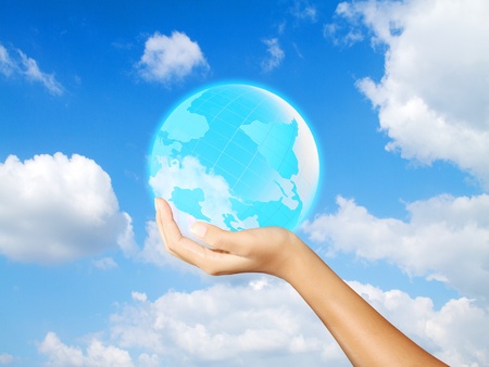 earth in hand on blue skyの写真素材
