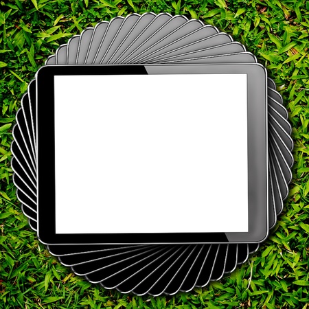 tablet computer pc with isolated screen on green grassの写真素材