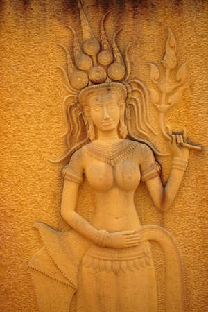 Religious statues on the wall in a Thai temple の写真素材