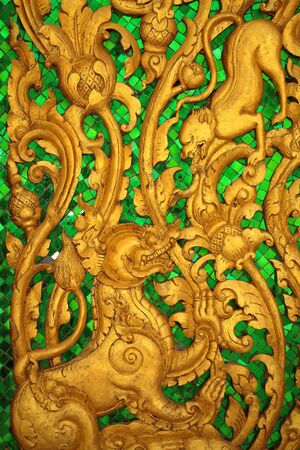 Animal carvings on the doors of the temple in the novel in a Thai temple の写真素材