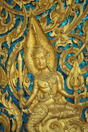 The carved angels on the doors of the temple in the Thai temple の写真素材