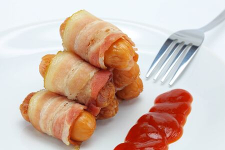 Bacon, sausage and sauce on a plate の写真素材