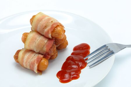 Bacon, sausage and sauce on a plate の写真素材