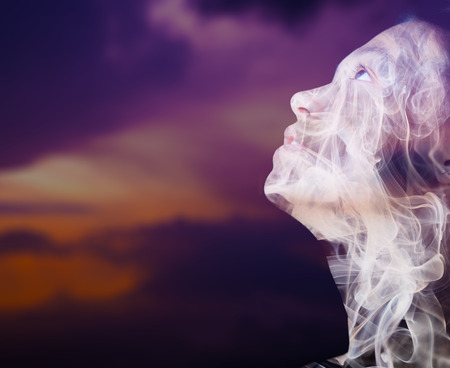 She hides behind layers of smokeの写真素材