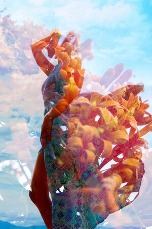 Double exposure photograph combining beautiful orange flowers with the profile of a standing woman...