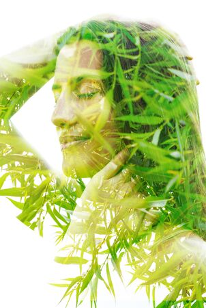 Double exposure close up portrait combined with bright green leavesの写真素材