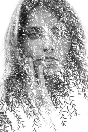 Double exposure portrait of a happy girl facing the camera and gently touching her face combined...