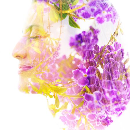Double exposure profile portrait combining beautiful purple flowers and branches with a woman's faceの写真素材