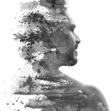 Paintography. Double exposure portrait of a man with strong features combined with handmade ink painting of brushstrokes which dissolve across his back and faceの写真素材