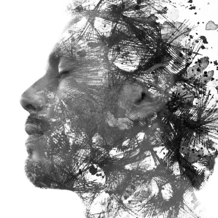 Paintography. Double exposure portrait of a man with strong features combined with handmade painting of repetitive lines which dissolve into his skinの写真素材
