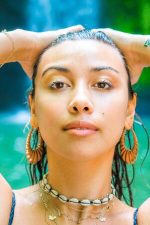 Closeup portrait of young Asian model swimming in a waterfallの写真素材