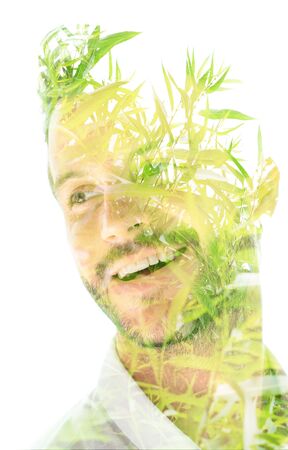 Double exposure close up portrait of an attractive smiling man combined with plants, created with an ecological conceptの写真素材