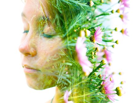 Double exposure portrait of a young girl combined with a photograph of flowersの写真素材