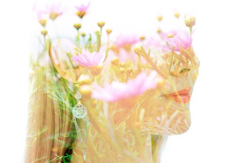 Double exposure portrait of a young woman combined with a photograph of flowersの写真素材
