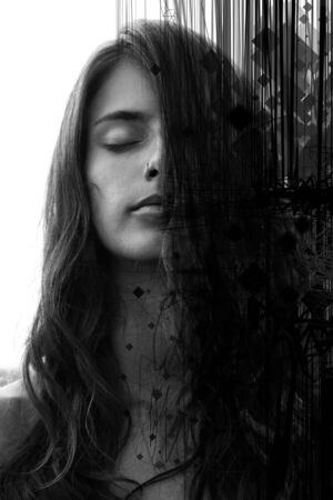 Portrait of a young pretty woman with closed eyes and long wavy hair partially covering her face