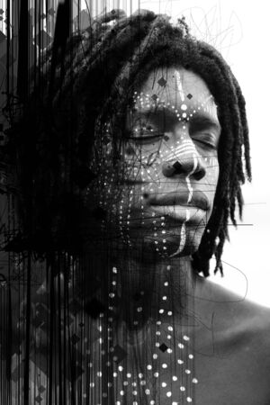 Portrait of young african man with closed eyes and traditional face paint shot at a three quarters...