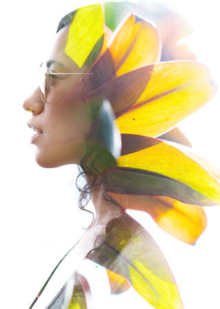 A double exposure portrait of a young woman profile with sun glasses against white background and tropical leavesの写真素材