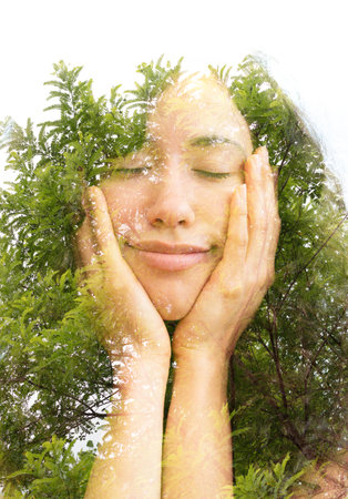 A double exposure portrait of a half smiling young woman with eyes closed dreaminly holding her chin...