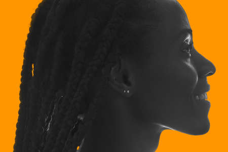 A balck and white profile portrait on yellow backgroundの写真素材