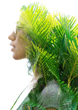 A double exposure portrait of a young woman profile with sun glasses against white background with...
