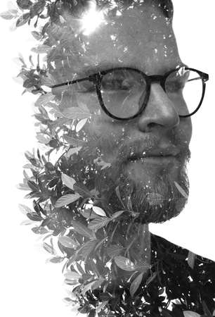 A double exposure portrait of a young man combined with foliage.の写真素材
