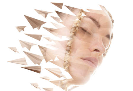 A portrait of a woman combined with paper planes in a double exposure technique.の写真素材