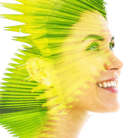 Vibrant double exposure portrait of a young woman and a palm treeの写真素材