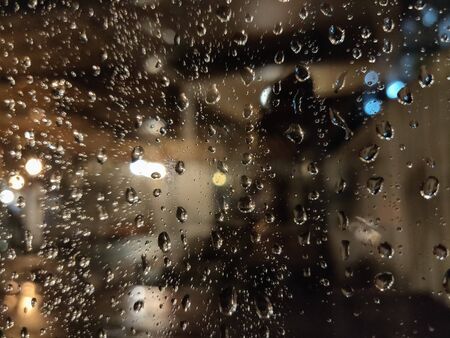The rain drop on the window at night.