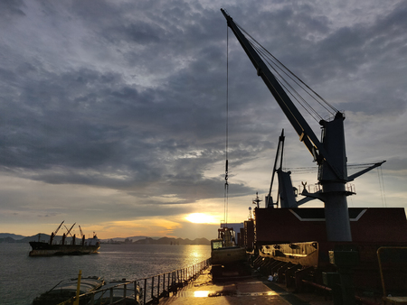 Discharging or loading operation on bulk ship in morning.