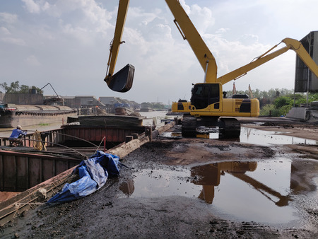 Excavator discharge coal at jetty.