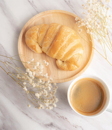 Fresh croissant and coffee on white marble background, top viewの写真素材