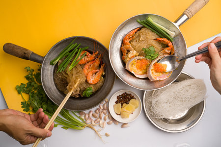 Shrimp and rice noodle in a pan on a yellow background