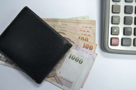 Black leather wallet with money and calculatorの写真素材