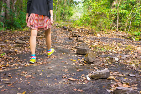 a girl is walking in a forestの写真素材
