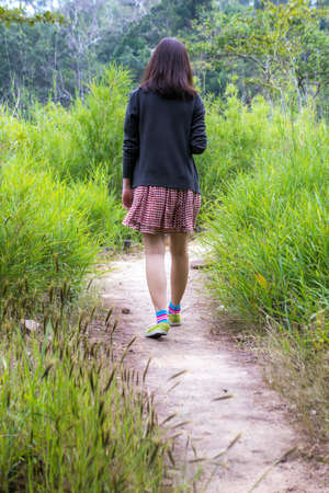 a girl is walking in a forestの写真素材