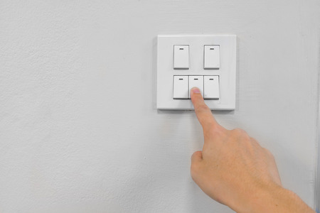 a finger is turning off the switch