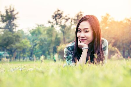 an asian woman is on a grass field in vintage colorの写真素材