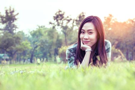 an asian woman is on a grass field in vintage colorの写真素材