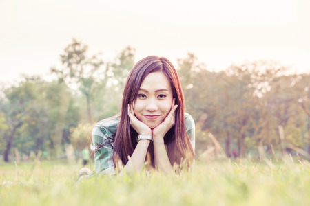 an asian woman is on a grass field in vintage colorの写真素材