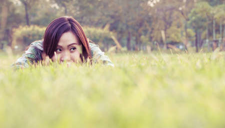 an asian woman is on a grass field in vintage colorの写真素材
