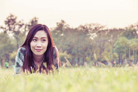 an asian woman is on a grass field in vintage colorの写真素材