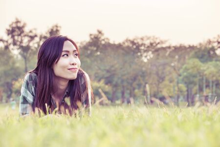 an asian woman is on a grass field in vintage colorの写真素材